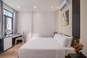 a bedroom with a large white bed and a desk at Hanami Residence - Self Check-in Accommodation in Danang