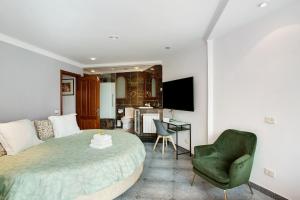 a bedroom with a bed and a chair and a television at Carmelo y Carmela 5 in Teror
