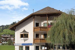 a building with a balcony on top of it at Rosalpina Apt 1 in San Vigilio Di Marebbe