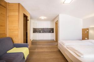 a bedroom with two beds and a couch at Rosalpina Apt 1 in San Vigilio Di Marebbe