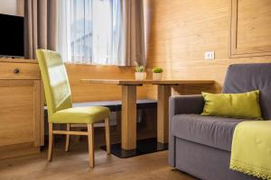 a room with a table and a chair and a couch at Rosalpina Apt 1 in San Vigilio Di Marebbe