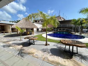 a resort with a pool and two benches and a resort at Flat 2 Suítes, piscina e churrasqueira em Alter in Alter do Chao