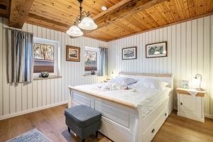 a bedroom with a white bed and a wooden ceiling at Hof Diederichs in Bohmstedt