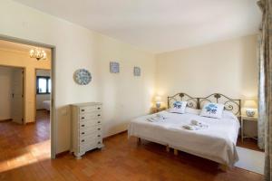 a bedroom with a bed and a dresser and a mirror at Casa Allan in Vale do Lobo