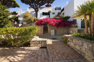 a brick walkway in front of a house with pink flowers at Casa Allan in Vale do Lobo