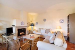 a living room with white furniture and a fireplace at Casa Allan in Vale do Lobo
