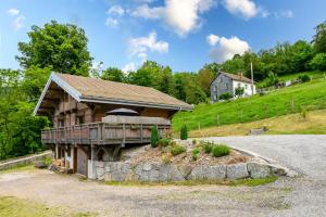 a log cabin on a hill with a house at Chalet du Piedmont in Cornimont