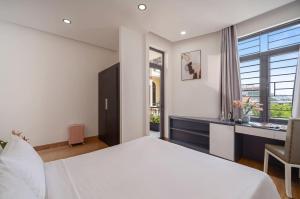a bedroom with a large white bed and a desk at Hanami Residence - Self Check-in Accommodation in Danang