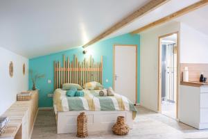 a bedroom with a bed and a blue wall at Studio proche Marais Poitevin in Oulmes