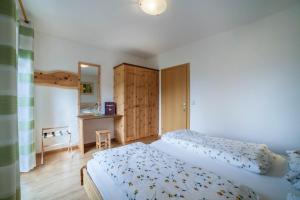 a bedroom with two beds and a desk in it at Langeshof Fewo Abendrot in Caines