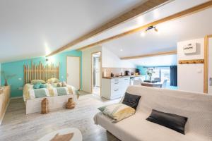 a bedroom with a bed and a couch and a kitchen at Studio proche Marais Poitevin in Oulmes