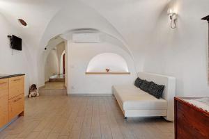 a living room with a white couch and an archway at Logge dei Paroloti Paolo in San Lorenzo in Banale