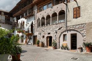 a stone building with an archway on a street at Logge dei Paroloti Paolo in San Lorenzo in Banale