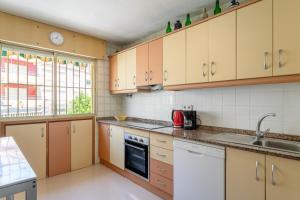 a kitchen with wooden cabinets and a sink at Casa La Roqueta in Guardamar del Segura