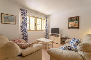 a living room with two couches and a tv at Casa La Roqueta in Guardamar del Segura