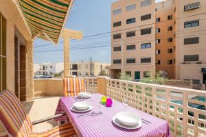 a table and chairs on a balcony with a view of buildings at Casa La Roqueta in Guardamar del Segura