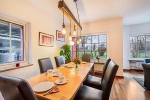 a dining room with a wooden table and chairs at Haus Rose Muc City in Munich