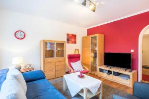 a living room with a blue couch and a tv at Haus Rose Muc City in Munich