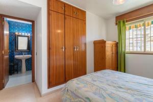 a bedroom with a bed and a bathroom with a sink at Casa La Roqueta in Guardamar del Segura