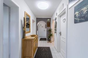 a hallway with a wooden dresser and a white door at Ferienwohnung Parzinger 2 in Chieming +20 photos