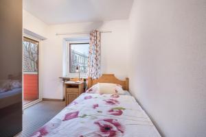 a small bedroom with a bed and a window at Haus Rose Muc City in Munich