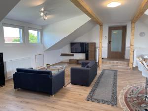 a living room with two couches and a table at promedklinik apartment 3 in Volkach