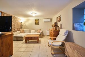 a living room with a couch and a tv at Gîte Les Dames in Mens