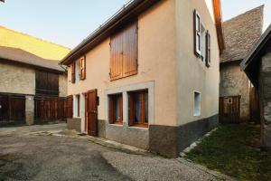 an old building with wooden doors and a street at Gîte Les Dames in Mens