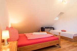 a room with two beds and a red bench at Ferienhof Sauter Romanshorn in Neukirch