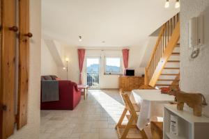 a living room with a dining room table and stairs at Ferienhof Sauter Romanshorn in Neukirch
