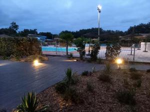 a courtyard with a swimming pool at night at Maison de vacances Proche Arcachon in La Teste-de-Buch +5 photos