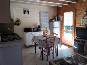a kitchen with a table and chairs and a refrigerator at Maison de vacances Proche Arcachon in La Teste-de-Buch