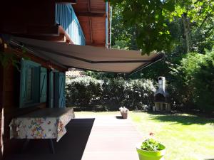 a porch of a house with an umbrella at Maison de vacances Proche Arcachon in La Teste-de-Buch