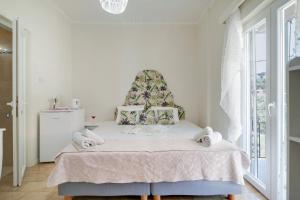 a white bedroom with a bed with a large window at M3 room in Nikiana +9 photos