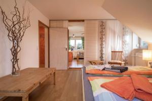 a living room with two beds and a wooden table at Ferienwohnung Tasoli in Lindau