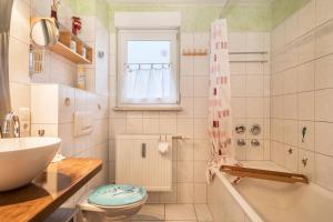 a bathroom with a sink and a toilet and a shower at Ferienwohnung Tasoli in Lindau +13 photos