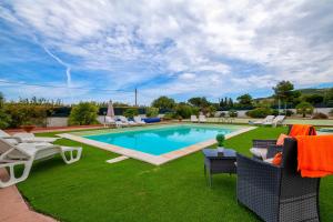 a backyard with a swimming pool and green grass at Villa Felicità in Sorso