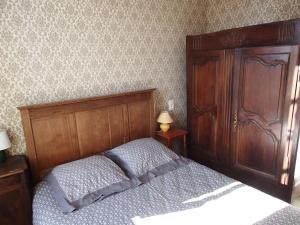 a bedroom with a bed and a wooden headboard at Appartement Authentique Montaigut in Gissac