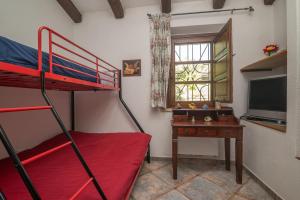 a bedroom with a bunk bed and a desk with a television at Stazzu La Piredda in Arzachena +33 photos
