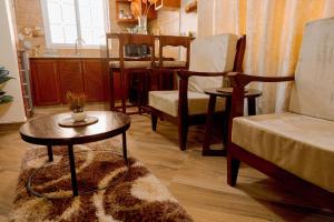 a living room with a table and chairs and a kitchen at Rhovee Homes in Moshi
