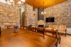 a dining room with a table and a stone wall at Ca La Pascola in Guimerá