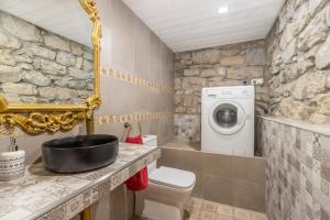 a bathroom with a toilet and a washing machine at Ca La Pascola in Guimerá +21 photos