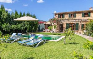 a group of chairs and an umbrella next to a pool at Casa Futbol in Sóller