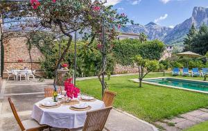 a table with a white table cloth and chairs and a pool at Casa Futbol in Sóller +15 photos