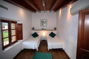 a room with two beds and a table with a lamp at Casa Futbol in Sóller