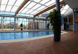 a large swimming pool in a large building at 2 bed apartment with pools and spa in Vera