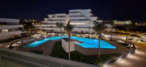 a view of a building with a swimming pool at night at Horus Beach Paradise in Torre del Mar