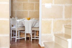 a table with chairs and a white table cloth at Casa de Ses Roques in Ciutadella