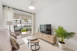 a living room with a couch and a flat screen tv at Horus Beach Paradise in Torre del Mar