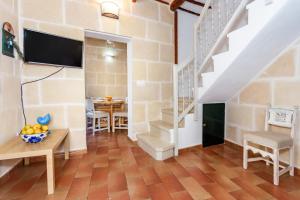 a living room with a staircase and a table at Casa de Ses Roques in Ciutadella